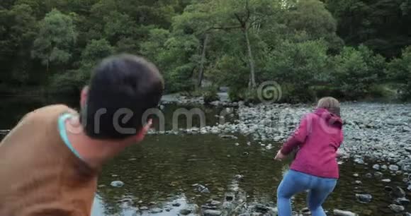 一对成熟的夫妇在湖上掠过石头视频的预览图