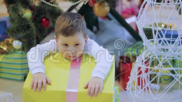 快乐男孩不想要新年礼物和悲伤坐在圣诞树下的孩子视频的预览图
