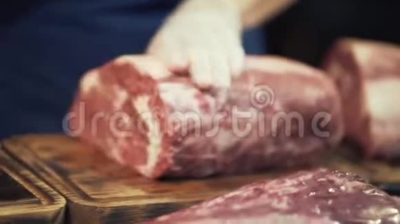 在白色防护手套中特写肉手准备一大块肉供烹饪或销售行动屠夫视频的预览图