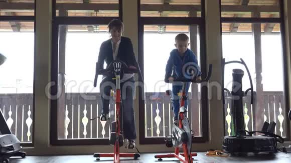 妈妈和小儿子在健身房练习静态自行车视频的预览图