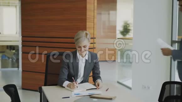 两位商务同事在现代办公室讨论报告女商人坐在桌子旁谈论他的男伴视频的预览图