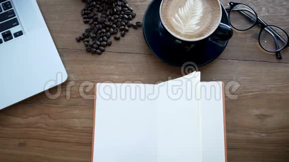 4K镜头摄影木桌上空白的白书风中翻页带笔记本的工作空间的书咖啡视频的预览图