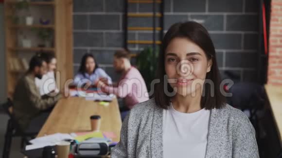 年轻开朗的女企业家在忙碌的创业办公室背景下看着镜头微笑的肖像视频的预览图