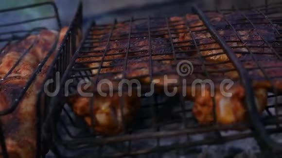 烧烤鸡肉鸡的翅膀在烤架上烤着慢动作视频的预览图
