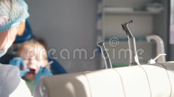 在牙科医生接待的女孩口腔医生给孩子清洗和浇水牙齿女孩微笑着说话视频的预览图