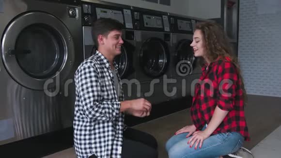 穿衬衫的帅哥在洗衣店向红卷发女人求婚她答应了视频的预览图