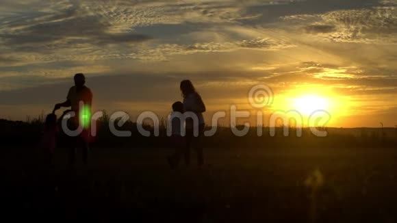 在乡村夕阳下和孩子们玩耍的父母剪影旅游旅游徒步旅行和人的概念视频的预览图