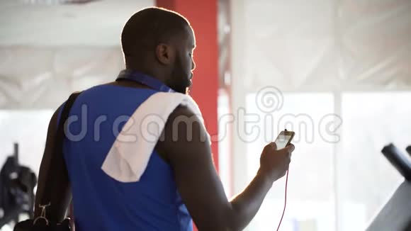 适合非洲裔美国男性在锻炼前在手机应用程序上欣赏喜爱的歌曲视频的预览图