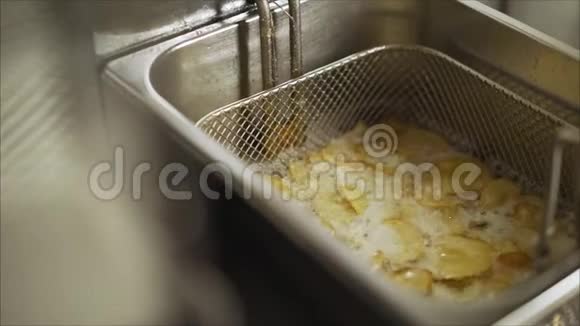 将炸薯条土豆放入炒锅中煮用热沸油深炒视频的预览图