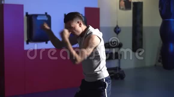 慢动作微光场景男拳击手在健身房训练皮影戏视频的预览图