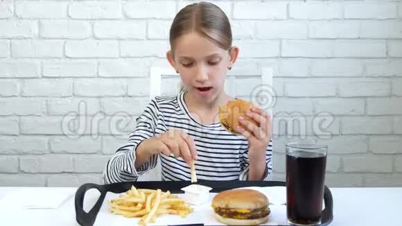 在餐馆吃汉堡的儿童吃垃圾快餐的小女孩视频的预览图