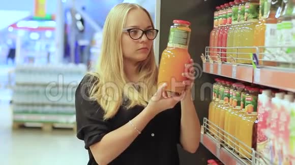 超市里的女孩选择果汁视频的预览图