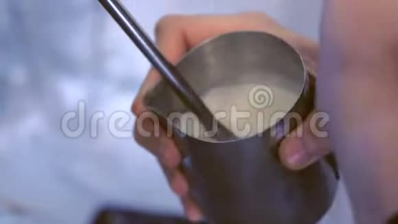 专业的男咖啡师准备新鲜咖啡拿着水罐蒸牛奶视频的预览图
