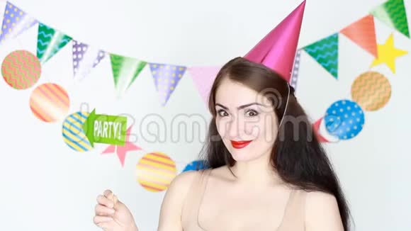 生日快乐那个戴着粉红色节日帽的滑稽女孩微笑着举着一个聚会的标志年轻快乐的肖像视频的预览图