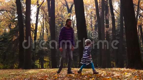 陷入困境的父亲和他的小女儿在秋天的森林里玩耍视频的预览图