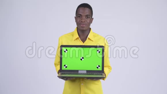 年轻快乐的非洲商人一边思考一边展示笔记本电脑视频的预览图