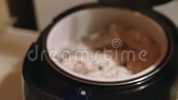 美丽的女人在家里用新的电动多人电脑烹饪鲑鱼视频的预览图