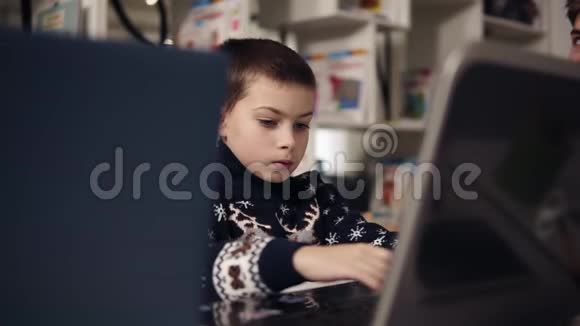 一个小男孩的大蓝眼睛试图学习如何使用笔记本电脑的Portait镜头教育过程视频的预览图