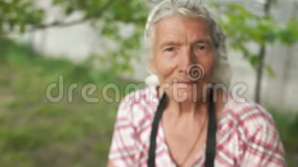 她花园里一个非常老的女人的特写肖像镜头靠近移开祖母戴着头巾视频的预览图