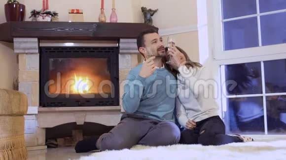 快乐的情侣在壁炉旁尽情享用香槟视频的预览图