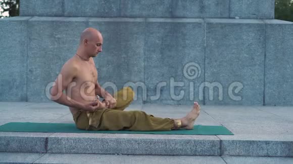 黎明时分在城市公园的地毯上用裸托索表演瑜伽的体式视频的预览图