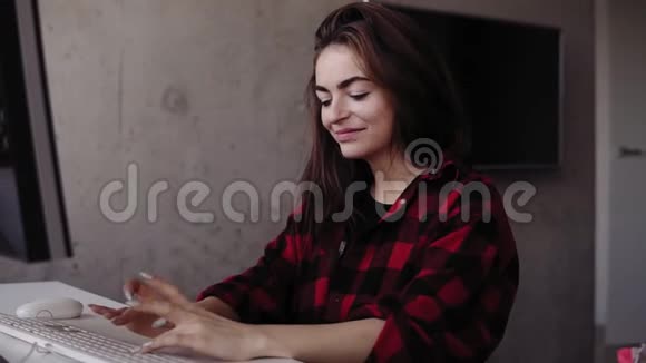 年轻有魅力的女孩在打字时坐在一个舒适的客厅里对一些事情感到情绪化视频的预览图