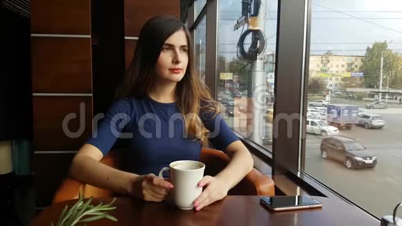 年轻漂亮的女孩在咖啡馆喝咖啡打电话在餐厅用餐的现代女性视频的预览图