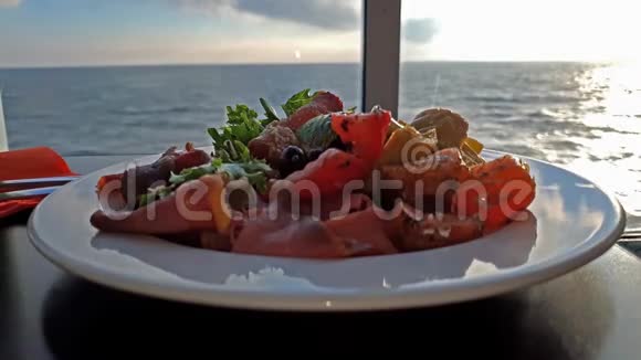 当游轮行驶时桌子上的沙拉盘以海洋为背景视频的预览图