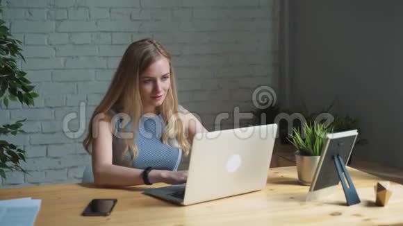 一位有创意的女士坐在办公桌前的肖像使用笔记本她坐在轻盈现代的办公室里视频的预览图