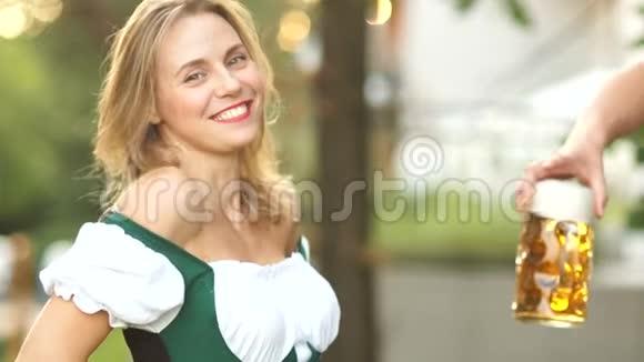 美丽的金发巴伐利亚女孩在啤酒节买啤酒女人开心笑她是视频的预览图