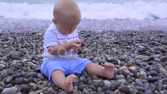 小孩子坐在沙滩上视频的预览图