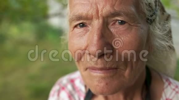 一个非常老的女人的详细画像她的头上戴着头巾在她的花园里工作相机停下来可以视频的预览图
