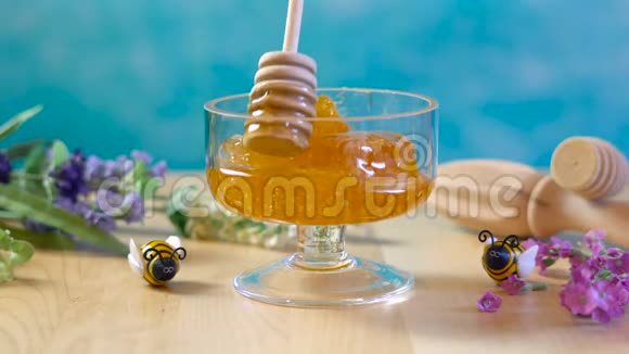 生蜂窝与液体蜂蜜在玻璃罐与拉文德视频的预览图