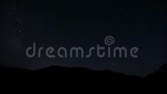 星空在黑暗的夜空中闪烁着星星轻云在夜空中飘荡在山上的星斗视频的预览图