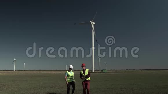 两名青年工程师男子走近风车视频的预览图