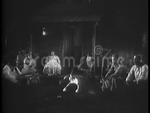 一群人在房子前面的篝火旁唱歌视频的预览图
