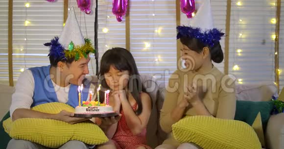 一个可爱的亚洲小女孩用蛋糕和幸福的家庭庆祝她的生日视频的预览图