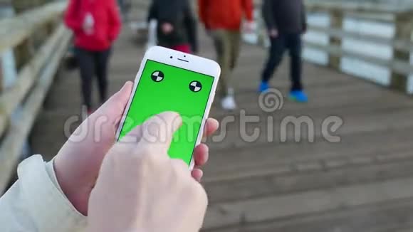 女子手持绿屏显示手机手指手势视频的预览图
