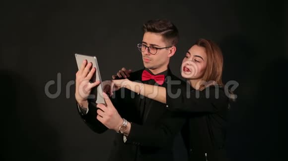 黑色背景上有平板电脑的情侣肖像视频的预览图