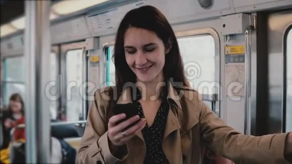 有魅力的女人在地铁里用智能手机美丽的年轻欧洲女孩在社交网络网页应用在线5G4K视频的预览图
