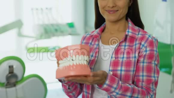 友好的女人展示下巴三维模型牙科护理的概念口腔卫生视频的预览图