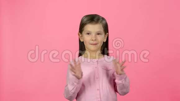 可爱的女孩在粉色背景上拍手视频的预览图