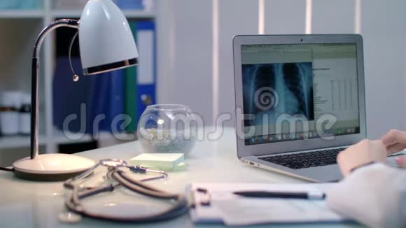 在工作场所用笔记本电脑处理xray的医生放射科医生检查X射线照片视频的预览图