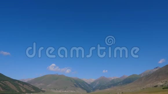 高地景观和蓝天山峰绿色草地上的大石头视频的预览图