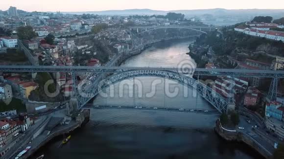 清晨在葡萄牙波尔图的杜罗河和多姆路易斯一号铁桥上空飞过里贝拉旧城区的鸟瞰图视频的预览图