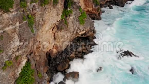 巨大的波浪从上面滚动俯视4k无人机在蓝色绿松石海洋上的视野破浪粉饰晴朗的一天视频的预览图