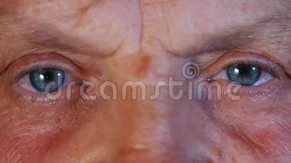 瞳孔的收缩中年妇女美丽的蓝眼睛虹膜有皱纹的老祖母视频的预览图
