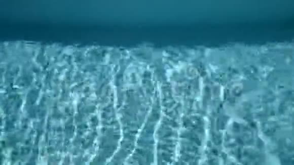 年轻的运动员有着轻盈的身体在清澈的游泳池里水下游泳热带地区的夏季视频的预览图