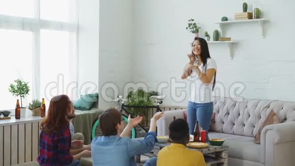 一群多民族的朋友在家玩派对游戏玩得很开心年轻的亚洲女孩展示某物或某人视频的预览图