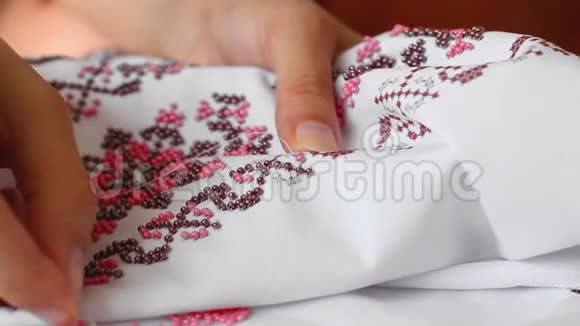 针与线的特写珠的刺绣图案手工缝制婚纱视频的预览图